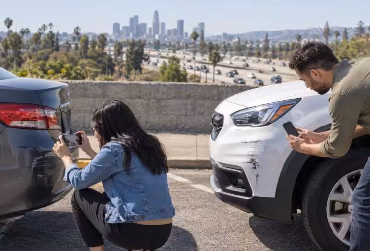 Illustrative scene of two drivers photographing vehicle damage after a freeway rear-end collision near Los Angeles