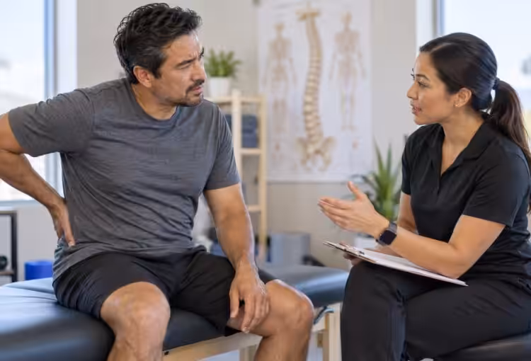 A patient discussing back pain and mobility with a clinician after a rear-end crash