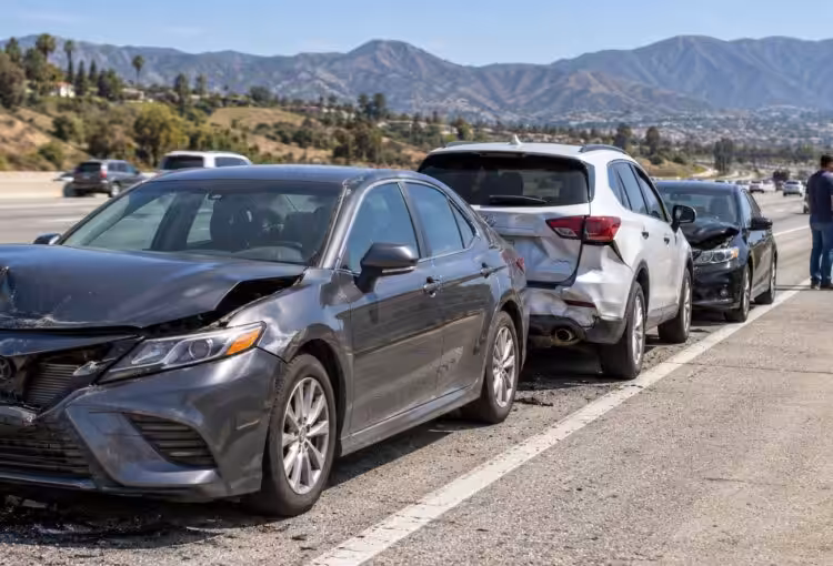 Several vehicles safely stopped on a Southern California freeway shoulder after a collision
